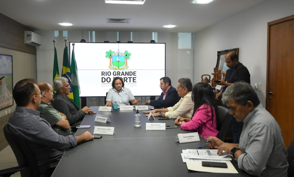 pessoal sentado na mesa em reunião