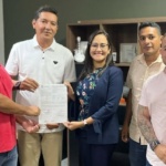 prefeito e equipe pousando com documento