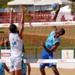 jogadores disputando bola em rede de praia