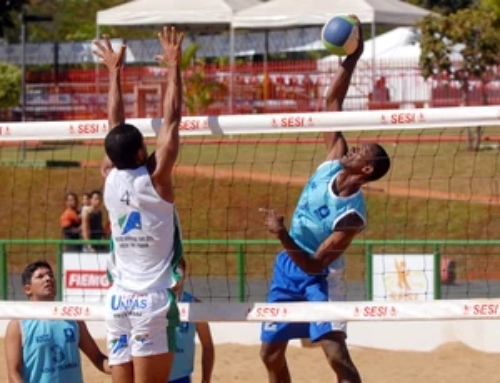 jogadores disputando bola em rede de praia